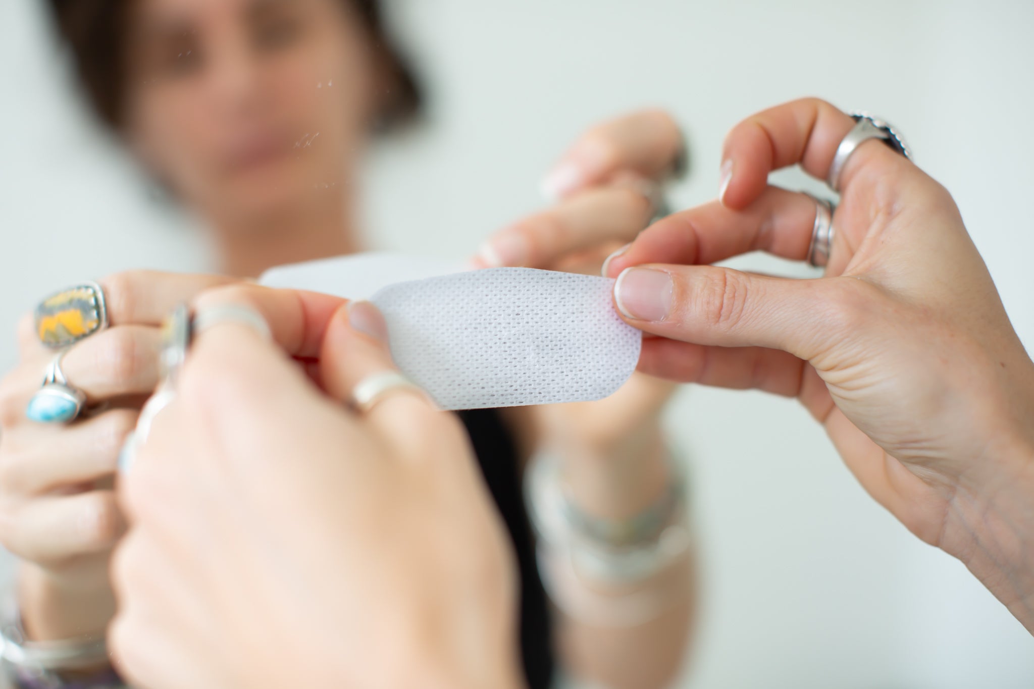 Woman holding a flexible strip of oi tape non-vented mouth tape in her hands